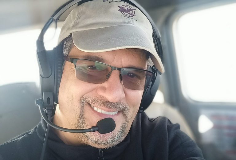 Capt. Gerald Toth Mann in Warnweste posiert vor einem Flugzeugtriebwerk auf dem Rollfeld.